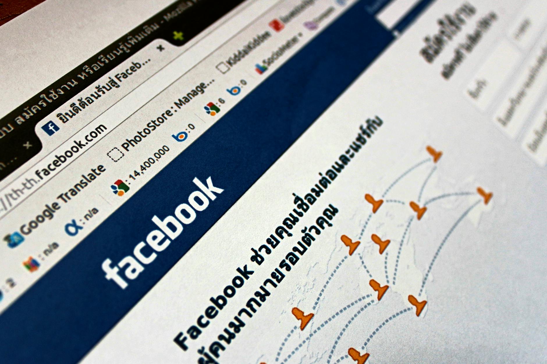 Zbliżenie ekranu z otwartą stroną Facebooka i ikonami social media